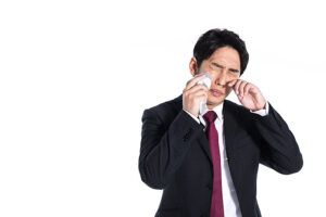 花粉症による目のかゆみの対処法を考えている男性