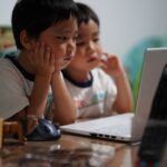 学校検診の視力検査結果（B・C・D）を受け、近視の進行を止めるための対処法や受診の目安について医師による診察や相談を受けている子供の様子
