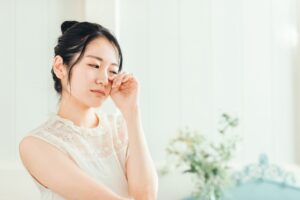 アレルギー性結膜炎の症状を特定し、適切な治療法や予防策を決定するために、医師による診察や相談を受けている女性の様子