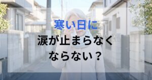 寒い日に涙が止まエアなくなり目をハンカチで拭いている女性。